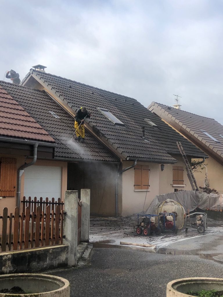 Un de nos ouvrier en train de démousser une toiture chez un particulier