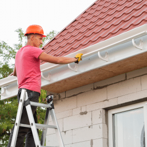 Particulier en plein nettoyage du chéneau de sa maison